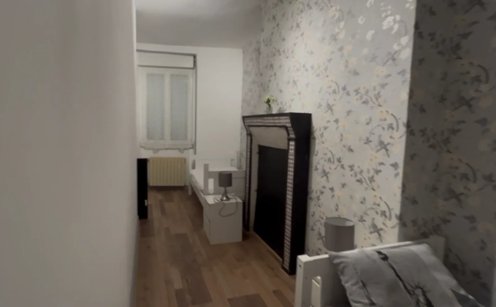 Bedroom with patterned wallpaper and period furniture